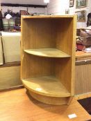 An oak floor corner shelf, of small proportions with rounded front, fitted single shelf, on plinth