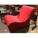 A Panton style chair, in red upholstery with rolled back and of continuous form (85cm x 68cm x