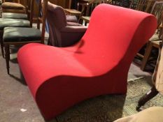 A Panton style chair, in red upholstery with rolled back and of continuous form (85cm x 68cm x