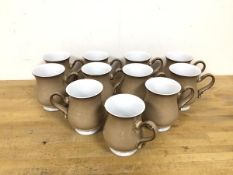 A set of eleven Denby mugs of tulip form with handles to side and cappuccino coloured ground (