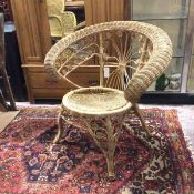 An Edwardian woven cane armchair with hooped back above foliate designed back and arms (80cm x