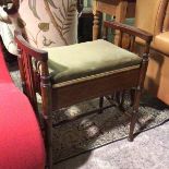 An Edwardian piano stool with raised pierced sides above a hinged upholstered seat, on turned