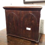 A 19thc mahogany table cabinet, with moulded top above a pair of Gothic style doors, fitted single