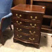 A reproduction Georgian style neat chest of drawers with serpentine front, fitted four drawers, on