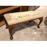 A 1930s/40s footstool, the grospoint top of floral design, on cabriole supports ending in pad