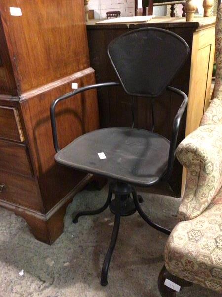 A metal office chair with fan shaped back above tube arms, on swivel base with four supports,
