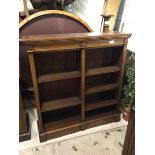 An Edwardian open bookcase, the rectangular moulded top above adjustable shelves in two sections, on