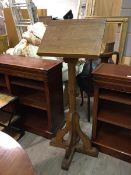 An early 20thc oak lectern with moulded supports on cross base (135cm x 50cm x 50cm)