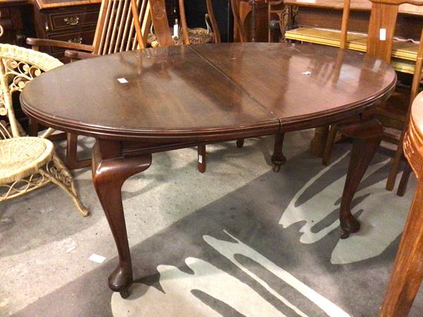 A 1930s/40s mahogany dining table, the oval top with moulded edge on cabriole supports ending in pad