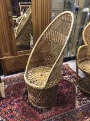 A woven wicker chair, the domed back with an outer ebonised cane gallery, circular seat and drum