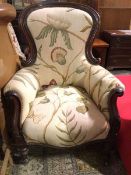 A Victorian spoon back armchair, the scroll arms with acanthus carving, in a floral linen