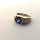 A gentleman's 9ct gold dress ring with oval set blue stone mounted in corner settings, with two