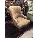 A Victorian nursing chair with foliate pattern upholstery, with serpentine front, on turned front