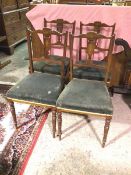 A set of four walnut Edwardian side chairs, the undulating top rail with boxwood inlay above pierced