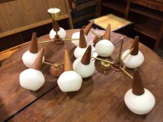 A pair of 1960s/70s brass and teak ceiling lights with three radiating arms, each ending in a teak