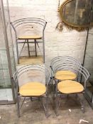 A set of four late 20thc. dining chairs with beech seats and curved painted metal backs (76cm x 61cm