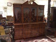 A modern yew wood Georgian style breakfront bookcase, with broken pediment above a dentil cornice,