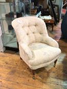 A Victorian style library chair with floral button back upholstery, on turned front supports