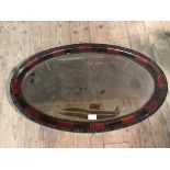 An Edwardian wall mirror of oval form, with beaded edge (47cm x 77cm)