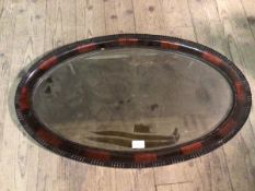 An Edwardian wall mirror of oval form, with beaded edge (47cm x 77cm)