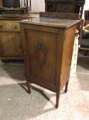 An Edwardian mahogany music cabinet, the ledgeback with swag moulding, the panelled door with