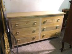 A modern light oak chest of drawers, the rectangular top above two rows of three drawers, the top