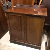 An Edwardian mahogany cupboard, with a concave ledgeback above an inlaid moulded top above two doors