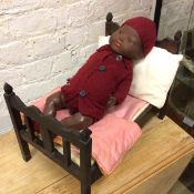 A vintage doll stamped AM Germany to back of neck (38cm) and a doll's bed and pillow (a lot)