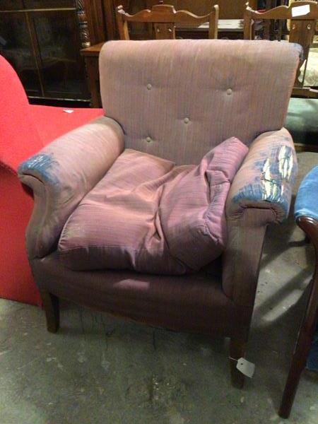 A 1920s/30s armchair, with button back above scroll arms, with cushion seat, on straight supports (