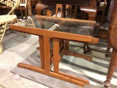 A set of three teak and glass nesting tables, the rectangular glass top above two nesting tables