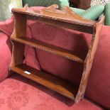 An Edwardian mahogany hanging shelf, with moulded three quarter gallery, above three shelves with