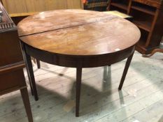 A 19thc mahogany dining table, comprised of two D ends, lacking leaves, with plain frieze on