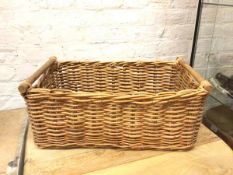 A wicker basket with raised turned handles (25cm x 66cm x 40cm)