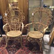 A pair of wicker armchairs with peacock backs, curved arms, with circular seats and curved