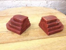 A pair of red stone Art Deco bookends, in the form of four tiered tablets (9cm x 15cm x 13cm)