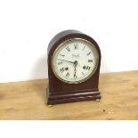 A Comitti of London mantel clock with dome top above a dial with roman numerals, on moulded base