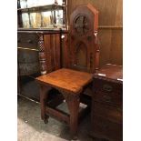 A late 19thc/early 20thc Gothic style hall chair, with an architectural back above a square seat,