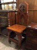 A late 19thc/early 20thc Gothic style hall chair, with an architectural back above a square seat,