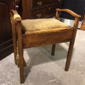 A 1920s/30s piano stool, stained beech, with handles to side above an upholstered hinged seat, on