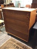 A mid century teak chest of drawers, the rectangular top above five graduated drawers, on straight