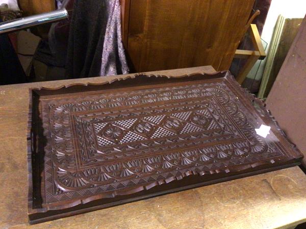 An Indian drinks tray with raised moulded edge and pierced handles to side, above intricately carved