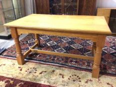 A Smallbone oak dining table, the rectangular top with moulded edge on turned supports united by H