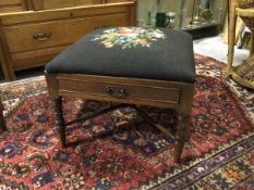 A 1920s footstool with grospoint upholstered drop in seat, above a single drawer, on turned supports