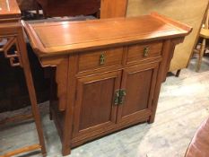 A Chinese side cabinet, the rectangular channelled top with raised sides above two frieze drawers