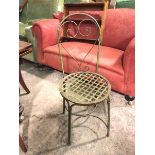 A metal garden chair, the arched back with a stylised pierced heart splat above a lattice seat, on