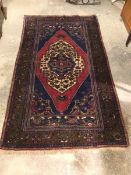 A North West Persian rug, with central diamond medallion, indigo field with flowerhead design,