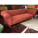 A late 19thc/early 20thc. sofa in a red wave pattern fabric upholstery, with curved back and arms,