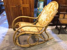 A cane rocking chair, with upholstered hump back and seat (103cm x 57cm x 130cm)