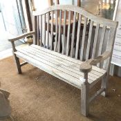 A garden bench, nicely weathered, with hump top rail over bannister back, with slatted seat on