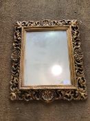 A rectangular wall mirror, the glass within a gilt composition frame with pierced foliate and